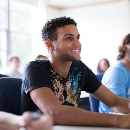 Academic Advising at Immaculata University - male student at desk in classroom smiling
